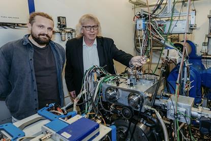 Researchers Aristidis Dafis (left) and Hermann Rottengruber pose with the single-cylinder experimental engine. The efficiency of fuel to mechanical work is claimed to be 60%, a full 10% higher than an equivalent diesel.