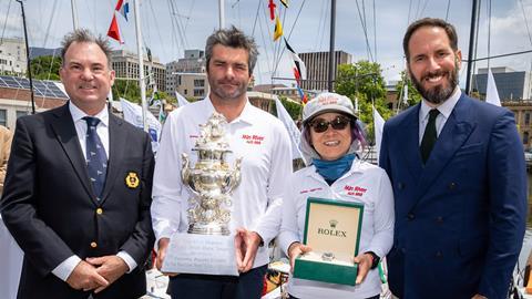 Jiang Lin and Alexis Loison of Min River celebrate their historic victory in the 80th Rolex Sydney Hobart Race as they receive the trophy